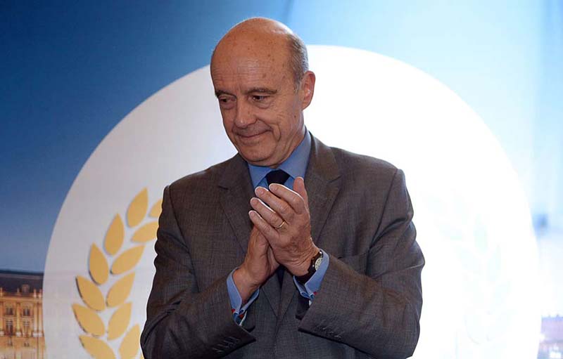 Mayor of Bordeaux and former French prime minister Alain Juppe applauds on April 24, 2015 in Bordeaux, southwestern France, prior to signing with the  French minister of Foreign Affairs a "destination contract" focused on the role of wine in French exports and enotourism (wine tourism).   AFP PHOTO / JEAN PIERRE MULLER