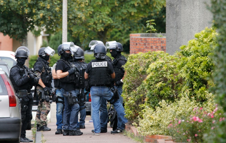 Des policiers devant une maison perquisitionnée à Saint-Etienne du Rouvray, le 26 juillet 2016. © AFP
