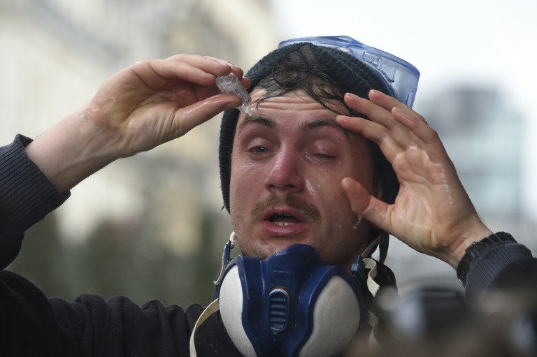 Un manifestant nettoie ses yeux au sérum physiologique après avoir reçu des gaz lacrymogènes, à Rennes, le 9 avril 2016 lors de la manifestation contre la loi travail. © AFP