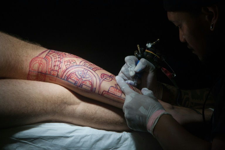 Une personne se fait tatouer lors du Festival international Polynesia Tatau, à Tahiti, le 3 avril 2016. © AFP